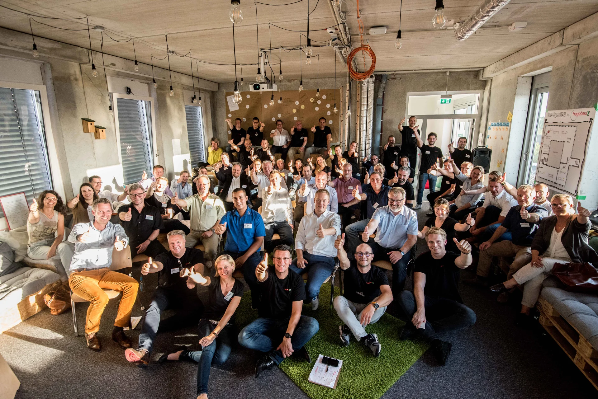 Group photo from a future workshop, around fifty participants with thumbs up