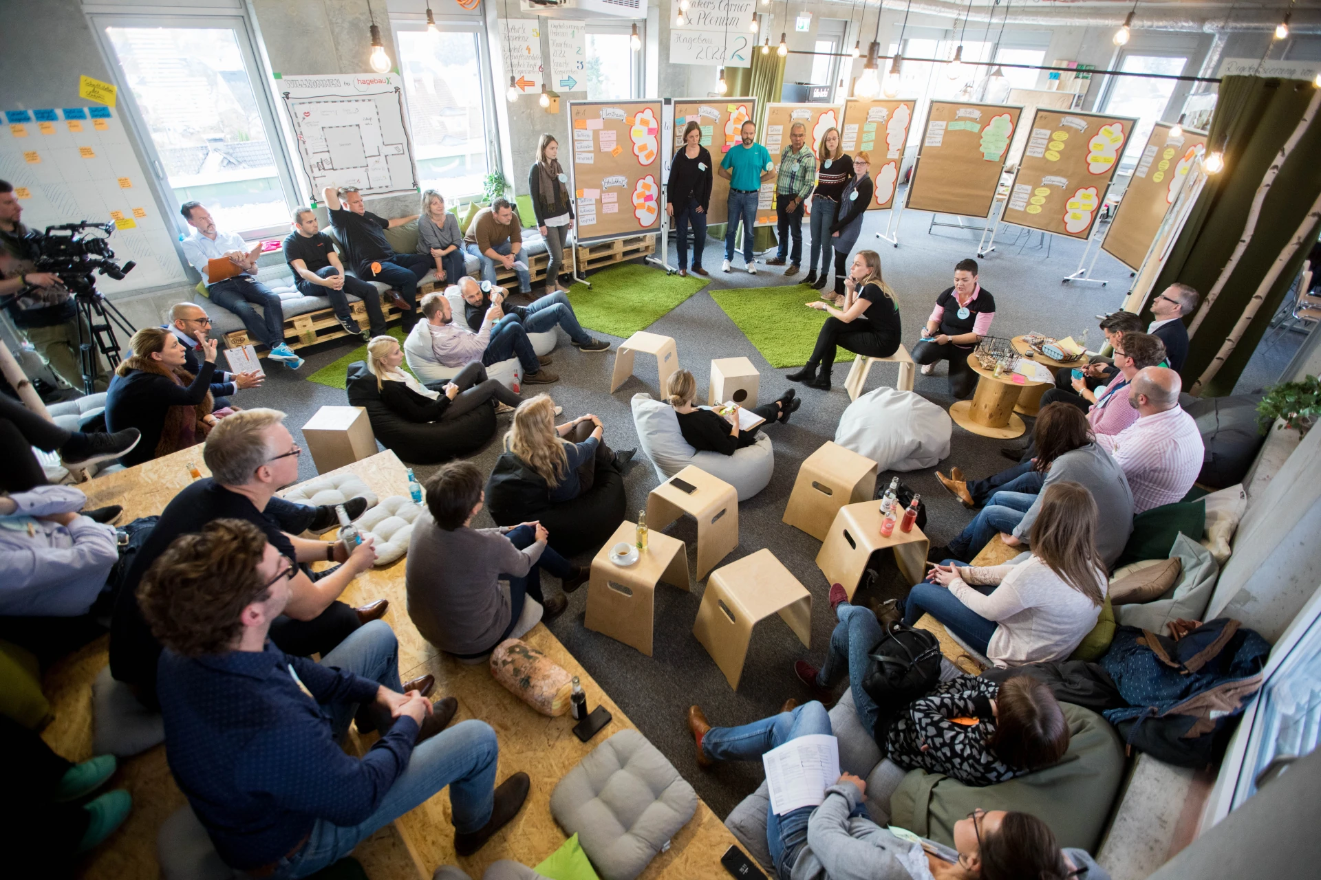 Future workshop in a circle of chairs, participants discussing in front of pinboards