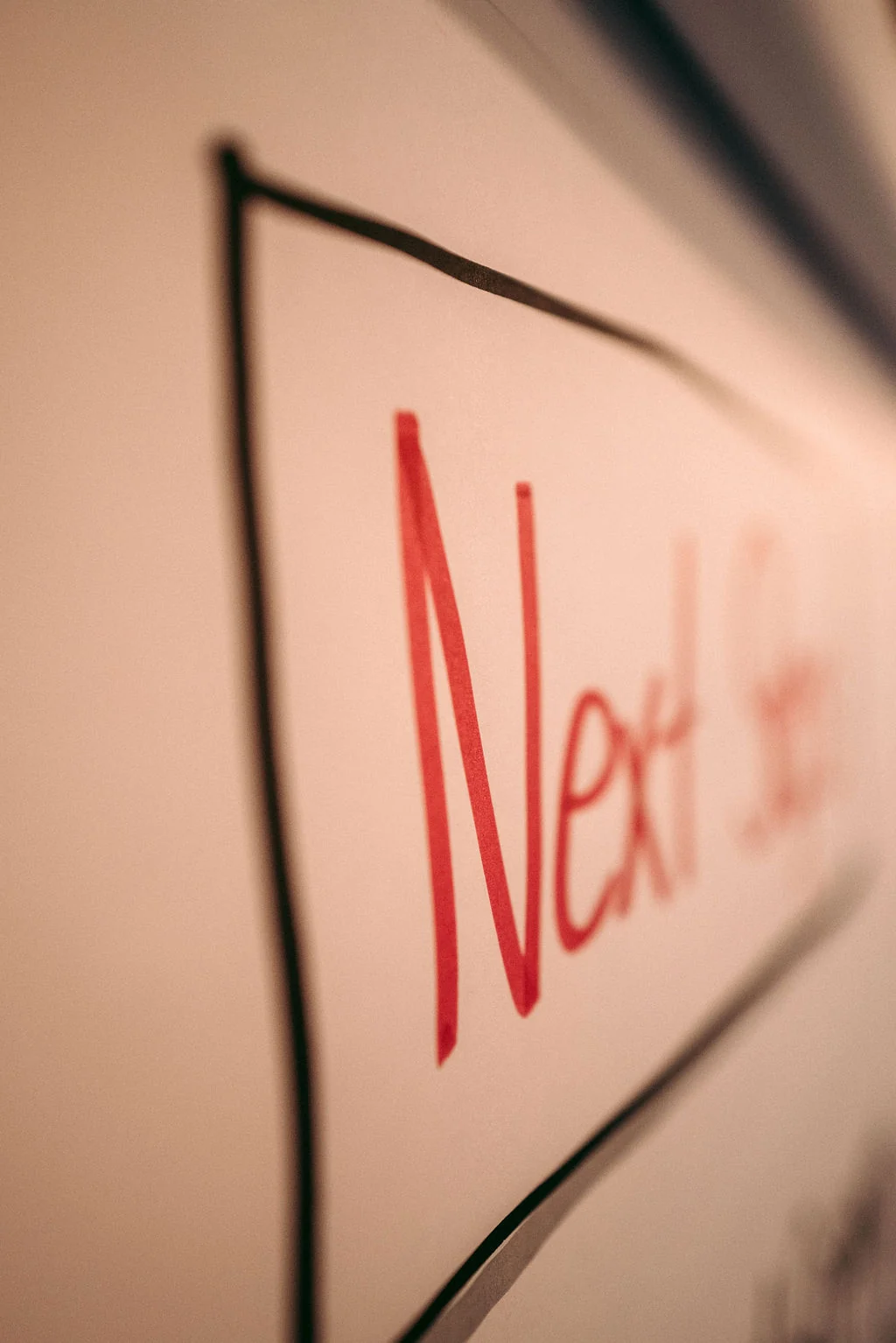 Whiteboard with the words Next Step handwritten in red