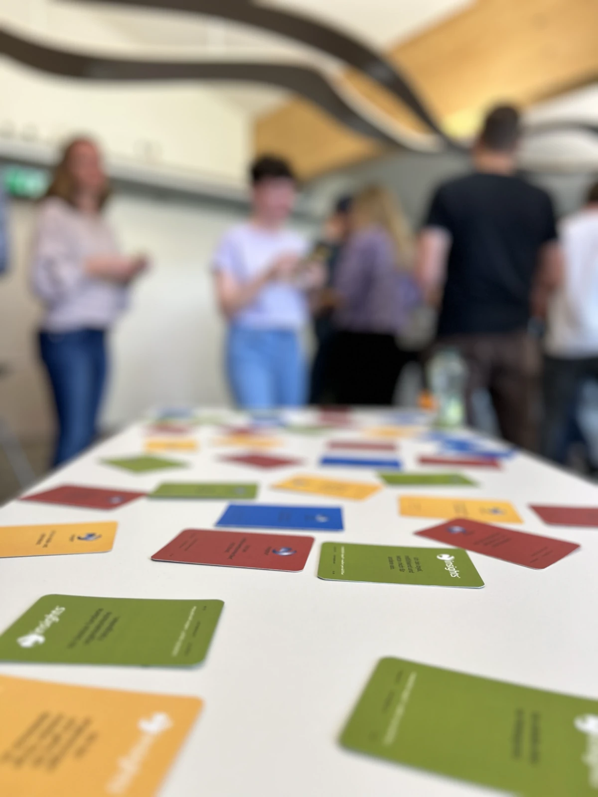 Coloured value cards on the table with workshop participants in the background