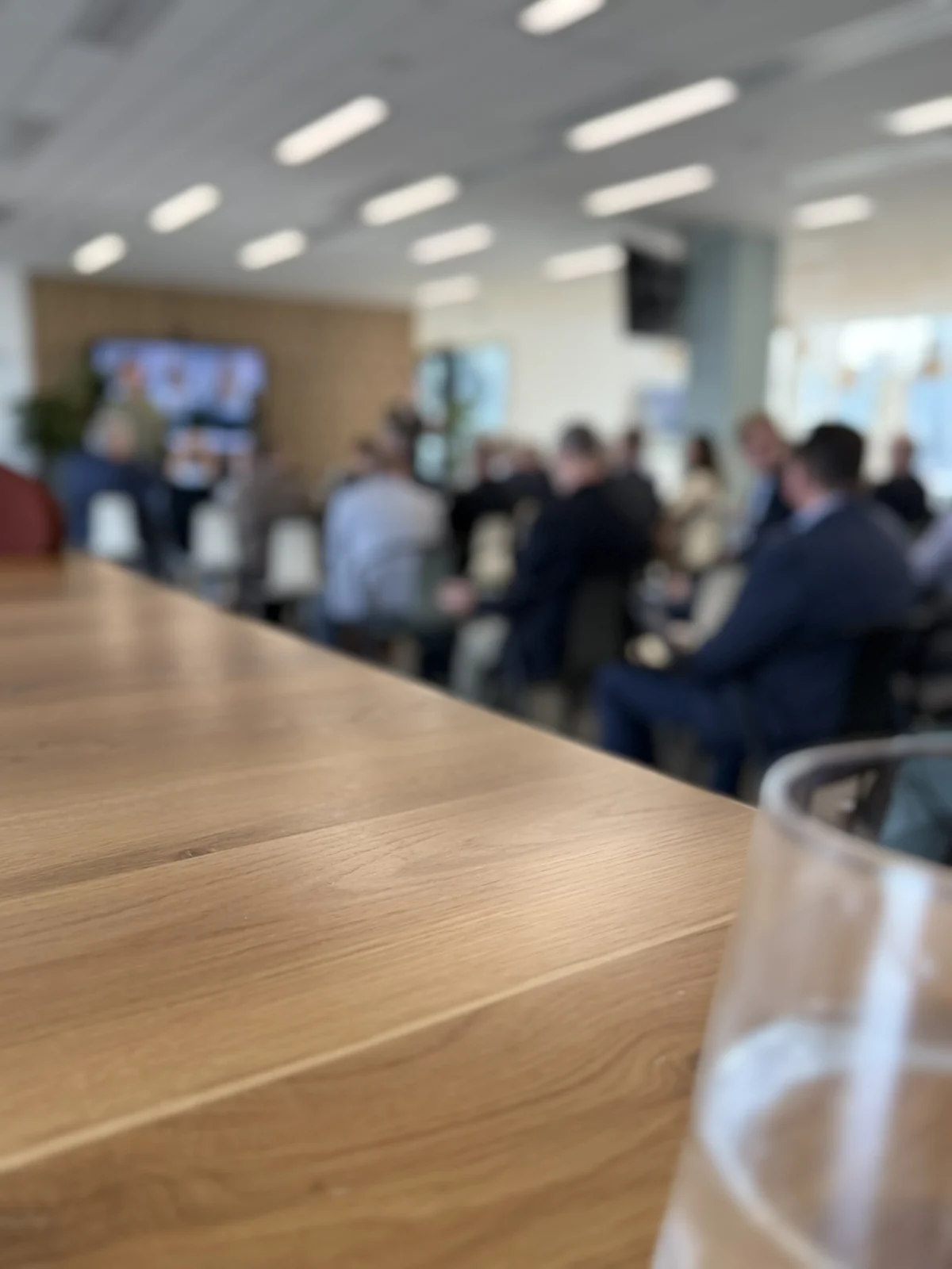 Managers talking at an event, the edge of a table in the foreground