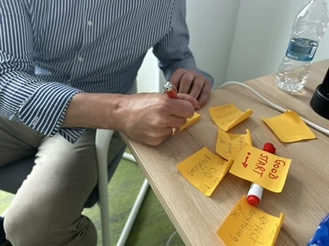 Participant writing on sticky notes, one of them reading Good Start