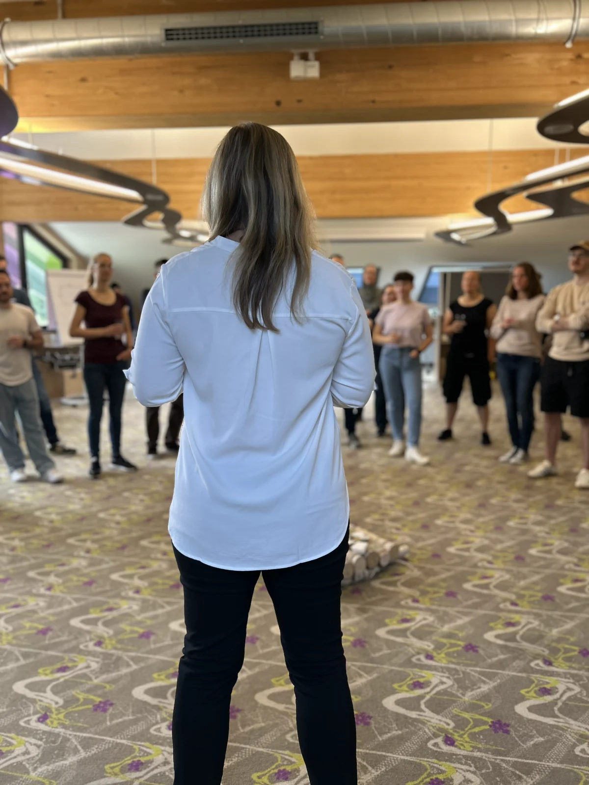 Facilitator standing in front of the leadership team gathered in a circle