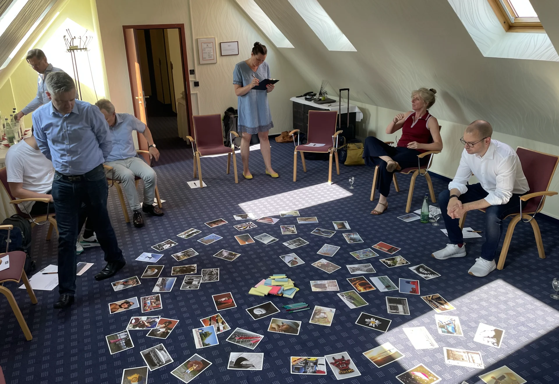 Leadership team in a circle of chairs with picture cards spread out on the floor